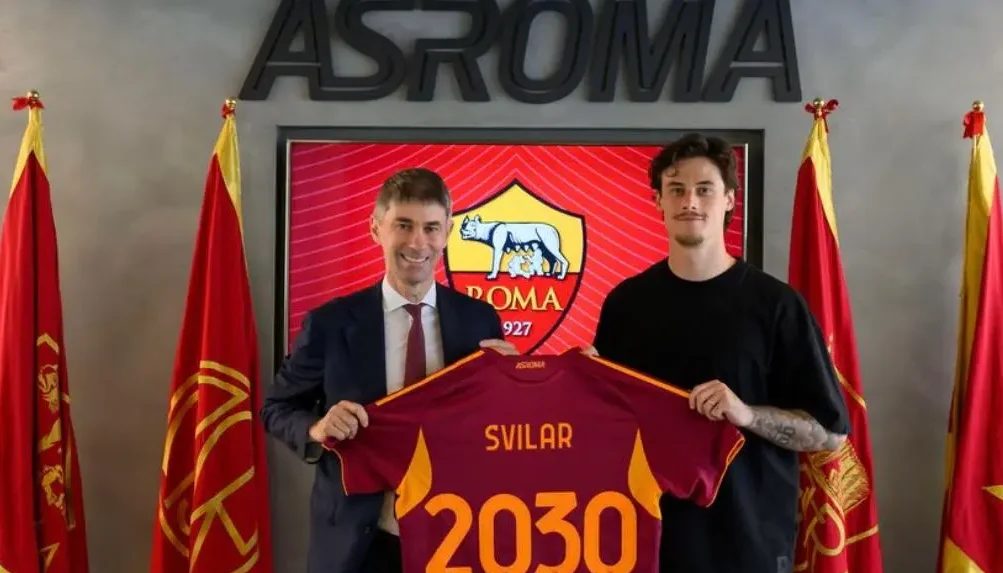 Mile Svilar posa insieme al ds giallorosso Massara con la maglia che annuncia il uso rinnovo di contratto con la Roma fino al 2030